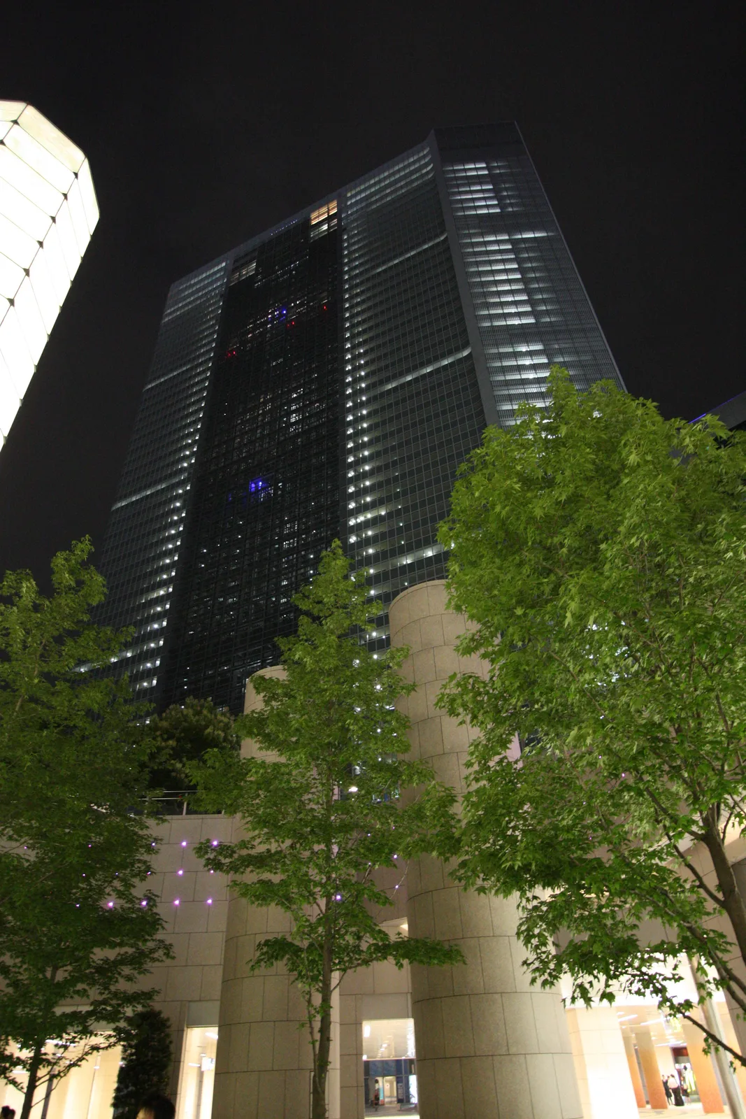 夜にライトアップされた高層オフィスビルの外観(電通グループ)