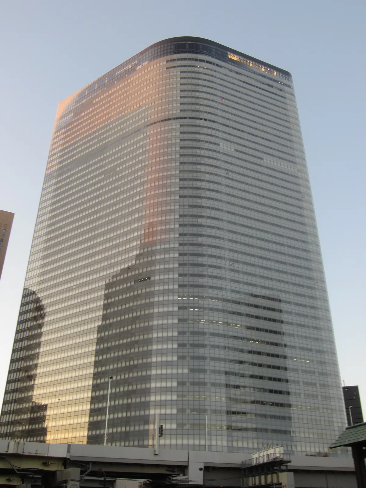 夕陽に照らされる高層オフィスビルの外観(電通グループ)