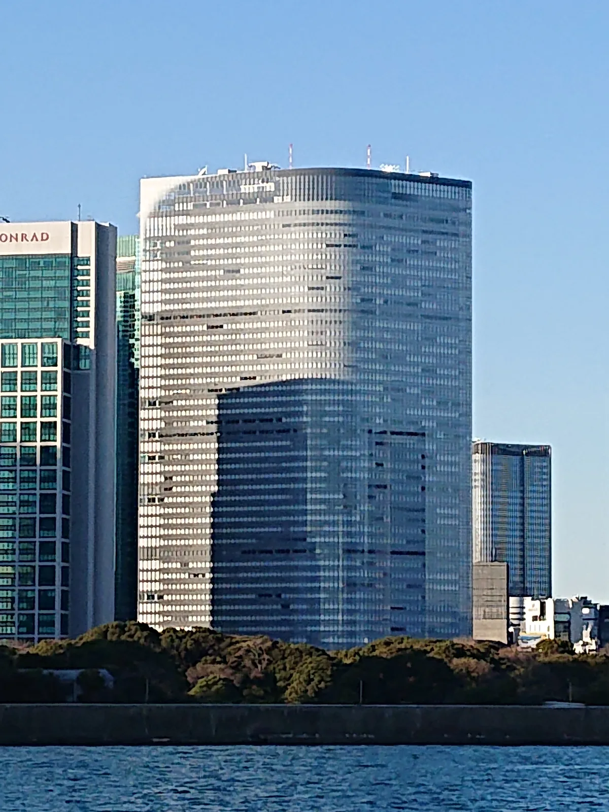 水辺越しに望む汐留の高層オフィスビル外観(電通グループ)