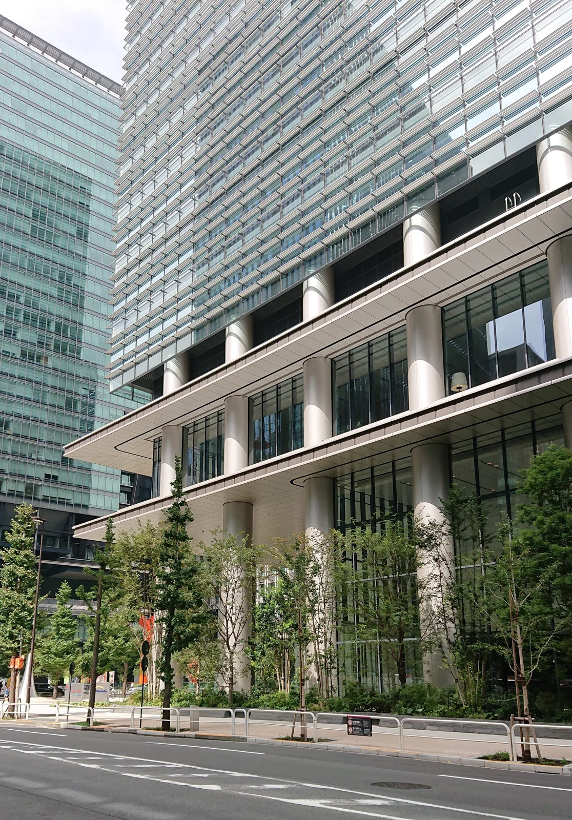 低層部の柱と緑が印象的なビル外観（住友商事）